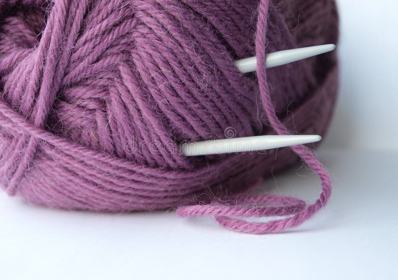 Ball of soft violet knitting yarn with needles sticking out of it. Ball of soft violet knitting yarn with needles sticking out of it