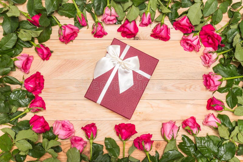 Top view fresh pink rose flower and gift box on wooden deck. For love or valentine day concept. Top view fresh pink rose flower and gift box on wooden deck. For love or valentine day concept