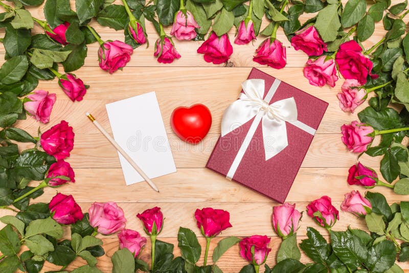 Top view fresh pink rose flower and gift box on wooden deck. For love or valentine day concept. Top view fresh pink rose flower and gift box on wooden deck. For love or valentine day concept