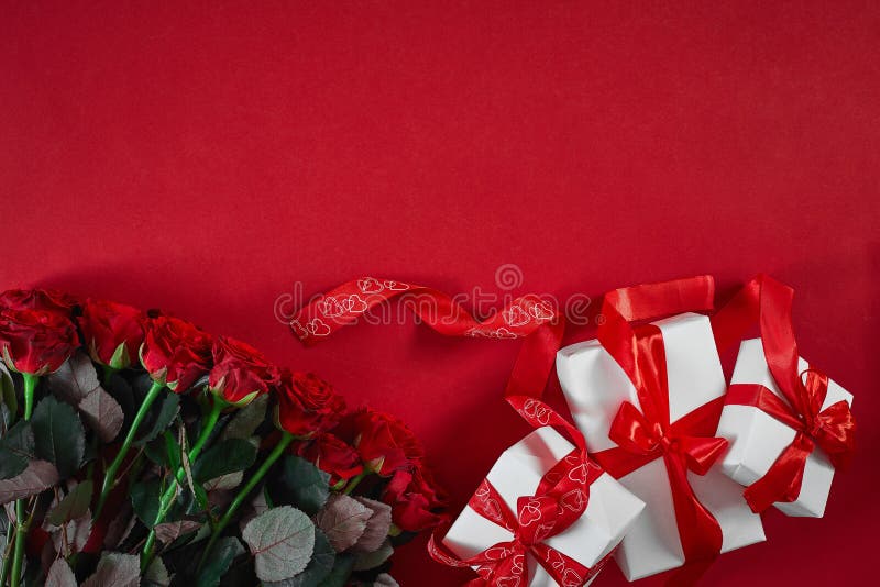 Top view fresh red rose flower and gift box on red deck with empty space for design. For love or valentine day concept. Top view. Copy space. Still life. Flat lay. Top view fresh red rose flower and gift box on red deck with empty space for design. For love or valentine day concept. Top view. Copy space. Still life. Flat lay