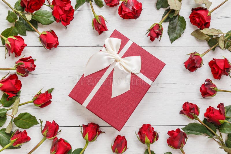 Top view fresh red rose flower and gift box on white wooden deck with empty space for design. For love or valentine day concept. Top view fresh red rose flower and gift box on white wooden deck with empty space for design. For love or valentine day concept