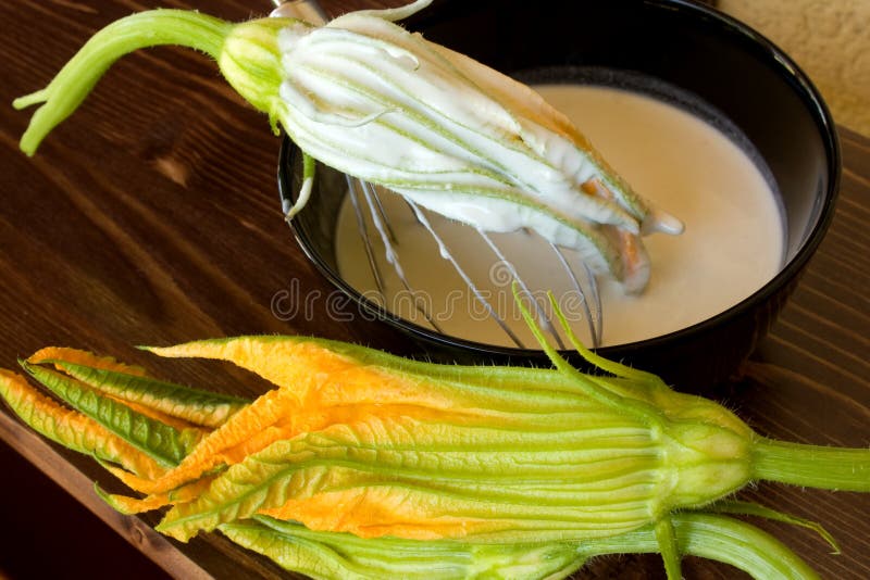 Food And Drinks - Italian Food - Fried zucchini flowers preparation - Closeup of zucchini flower in the batter. Food And Drinks - Italian Food - Fried zucchini flowers preparation - Closeup of zucchini flower in the batter.