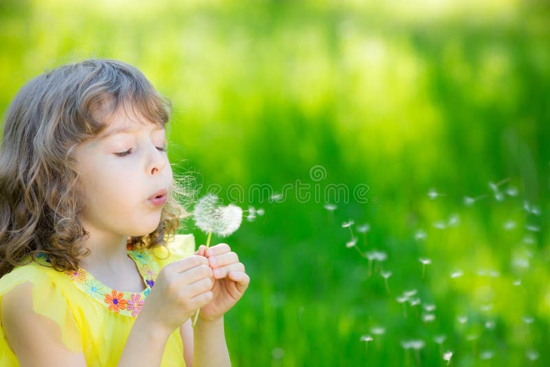Fiore di salto del dente di leone del bambino felice all'aperto fotografia stock Fiore di salto del dente di leone del bambino felice all'aperto fotografia stock