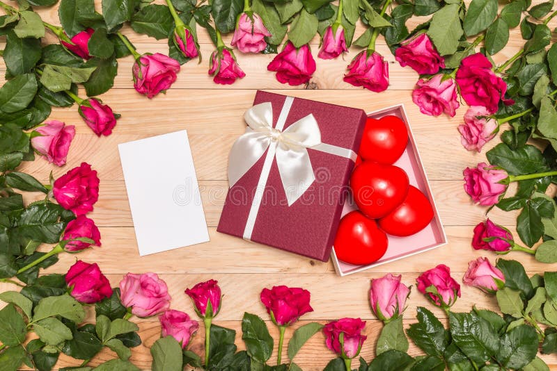 Top view fresh pink rose flower and red heart on wooden deck. For love or valentine day concept. Top view fresh pink rose flower and red heart on wooden deck. For love or valentine day concept