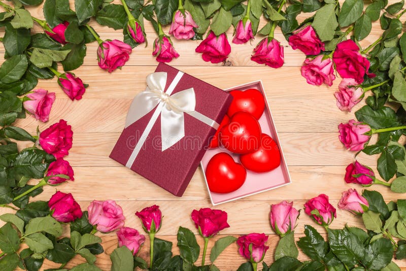 Top view fresh pink rose flower and red heart on wooden deck. For love or valentine day concept. Top view fresh pink rose flower and red heart on wooden deck. For love or valentine day concept