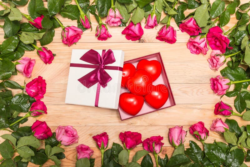 Top view fresh pink rose flower and red heart on wooden deck. For love or valentine day concept. Top view fresh pink rose flower and red heart on wooden deck. For love or valentine day concept