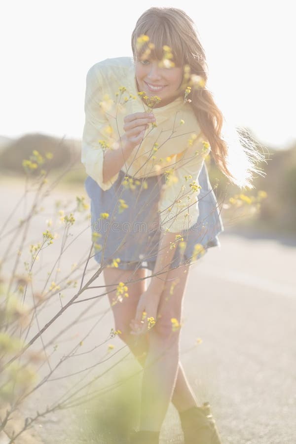 Fiori odoranti della ragazza allegra dei pantaloni a vita bassa fotografie stock Fiori odoranti della ragazza allegra dei pantaloni a vita bassa fotografie stock