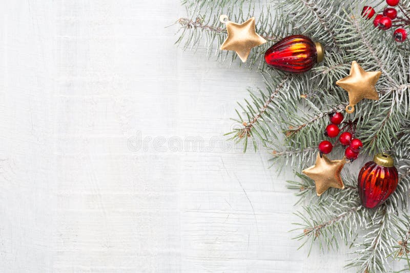 Fir branch with Christmas decorations on white rustic wooden background with copy space for text