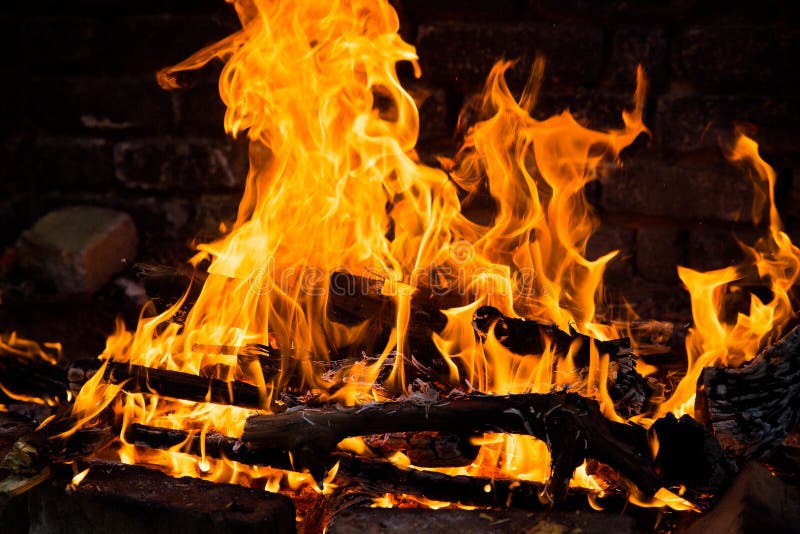 Fire Burning in a Brick Fireplace. Red and Yellow Flames Stock Photo