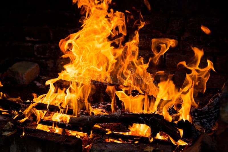 Fire Burning in a Brick Fireplace. Red and Yellow Flames Stock Photo