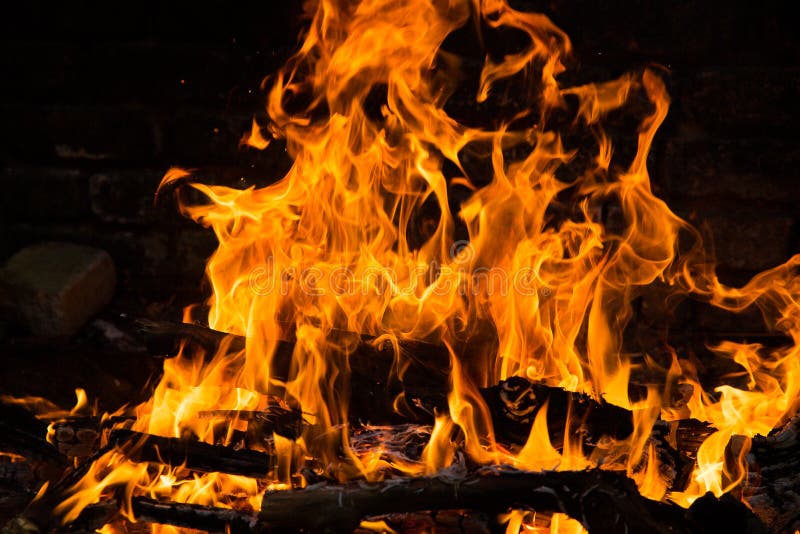 Fire Burning in a Brick Fireplace. Red and Yellow Flames Stock Photo