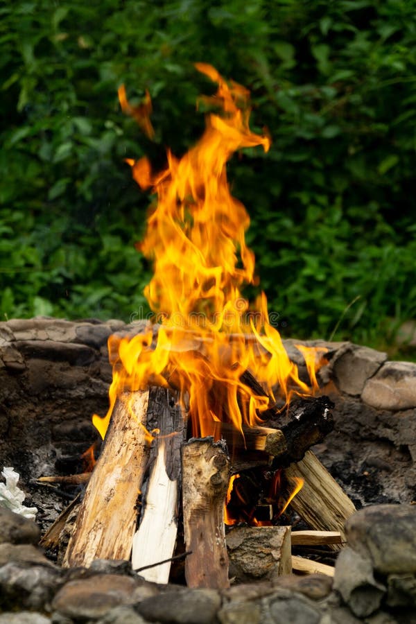 Hořící oheň v krbu v přírodě nebo na grilu.