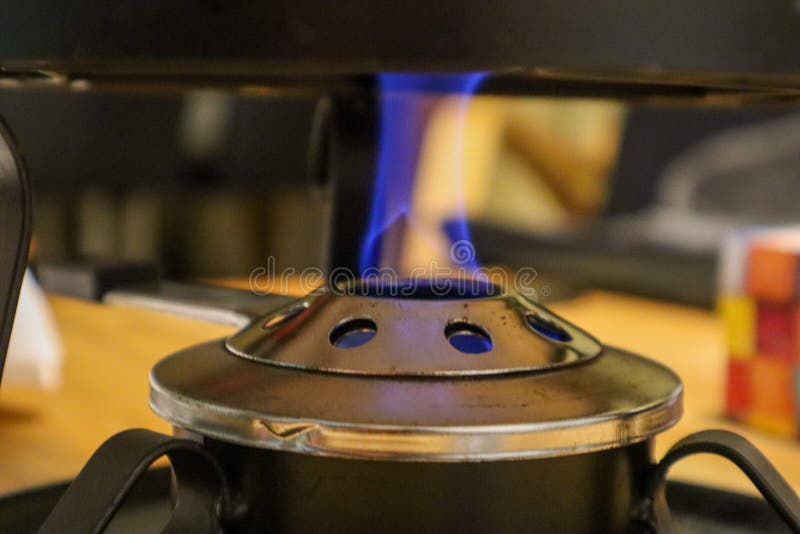 The Fire for the Caquelon Cooking for Swiss Cheese Fondue Stock Photo Image of melt
