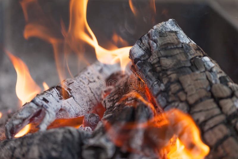 Fire with charcoals. Burning wood. Macro. Live flames with smoke. Wood with flame for barbecue and cooking bbq. Bright color.