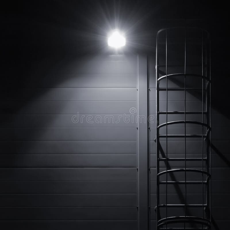 Fire emergency rescue access escape ladder stairway, roof maintenance stairs at night, bright shining lantern lamp light. Building, architecture.