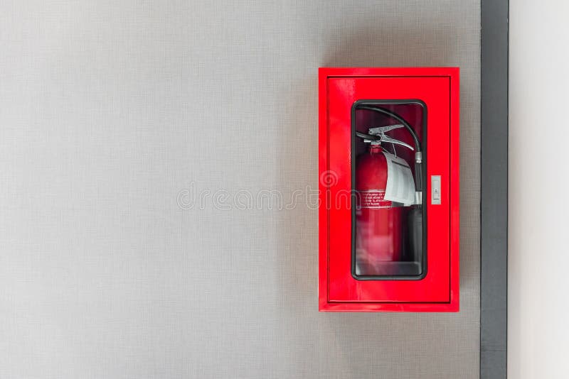 Fire extinguishers cabinet on grey wall stock image