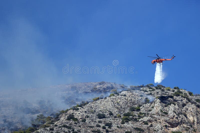 Fire helicopter extinguishes the fire on the hillside . Greece.