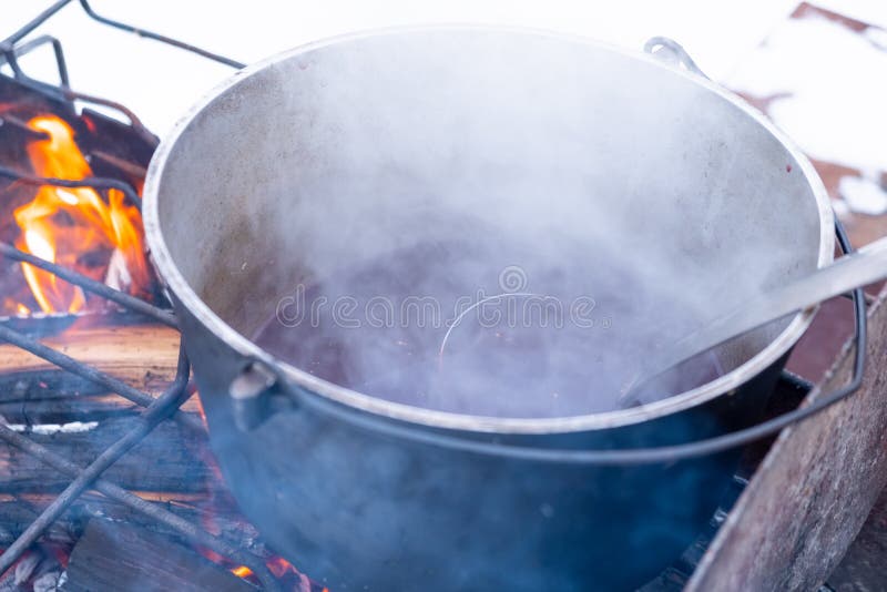 On a Fire in a Pot Preparing Mulled Wine. Hot Red Wine on an Open Fire