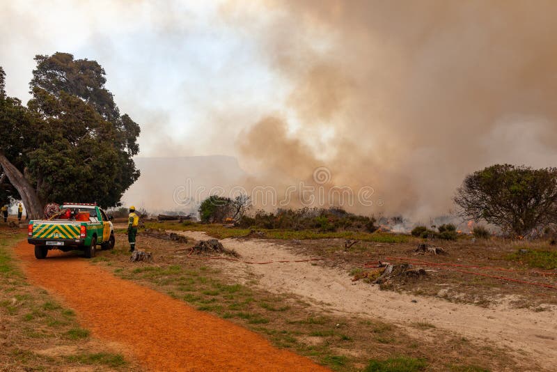 A fire truck sits watch over a veld in cape Town during a fire.