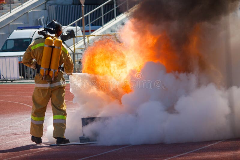 Firefighter in equipment extinguishes fire