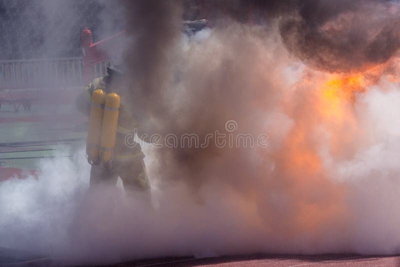 Firefighter in equipment extinguishes fire