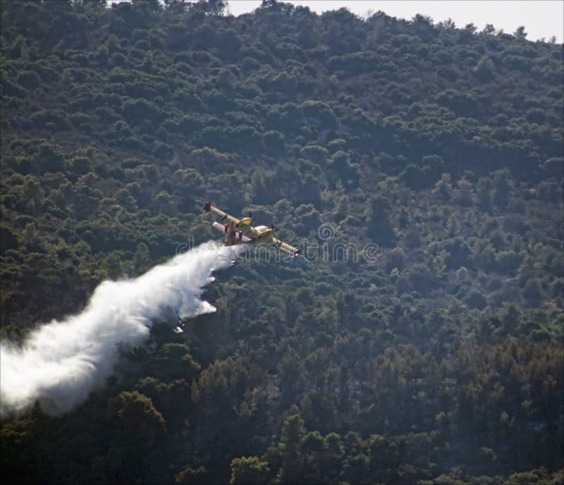 Firefighter plane dropping water over a fire royalty free stock image