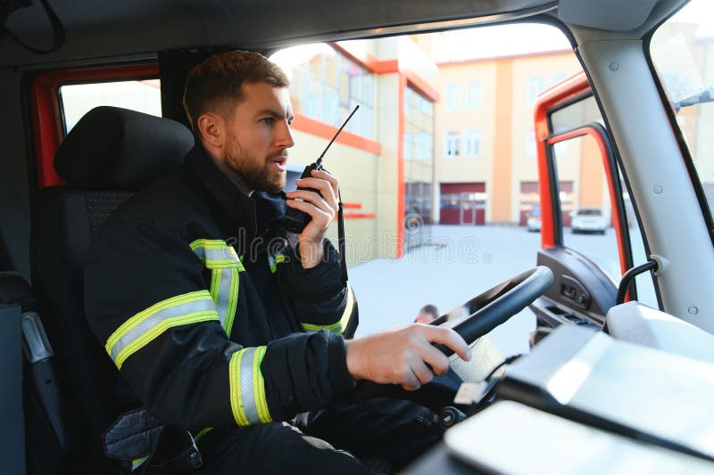 Firefighter Using Radio Set while Driving Fire Truck Stock Image