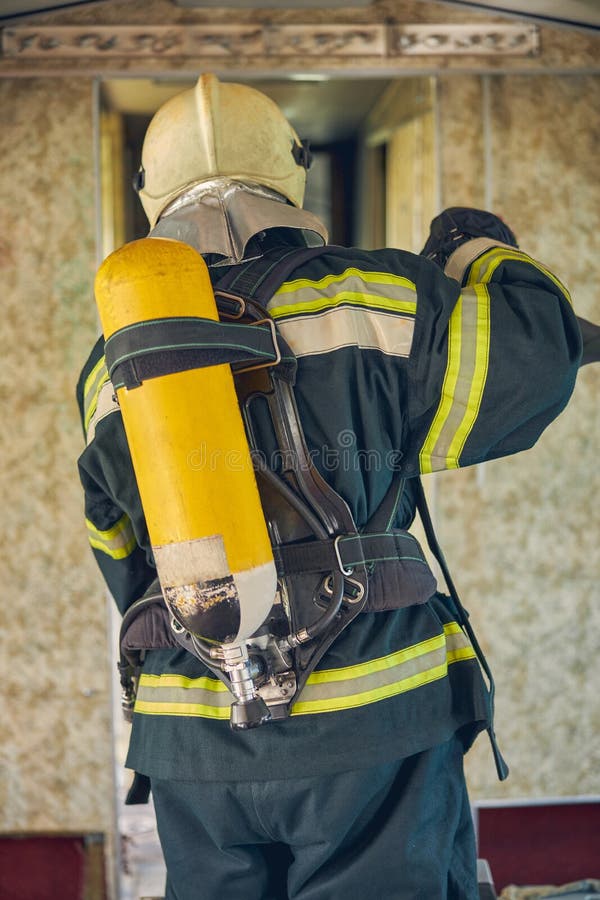 Firefighter Wearing Fireproof Uniform Standing in the Indoors Stock