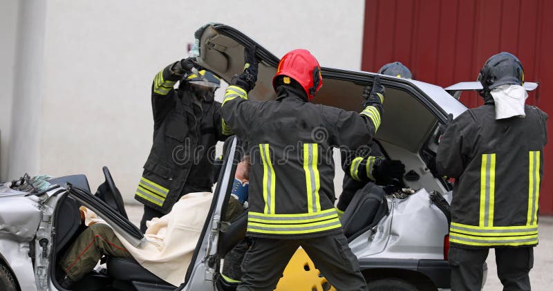 firefighters in action during the rescue of the injured after the car accident with the stretcher to transport the injured