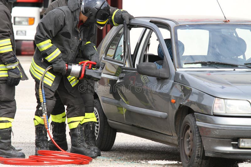 Firefighters with Shears Open the Car Doors after a Serious Car Stock