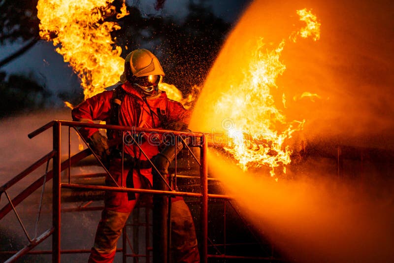 Firefighters using water fog spraying down fire from oil rig factory explosion