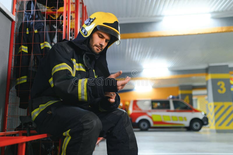 Fireman sitting on bench at fire station royalty free stock images