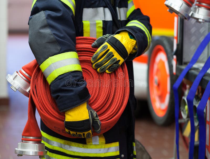 A Fireman with water hose stock photo. Image of reach 53472056