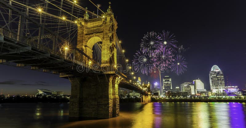 Fireworks over Cincinnati, Ohio with John A Roebling suspension bridge reflecting in river. Fireworks over Cincinnati, Ohio with John A Roebling suspension bridge reflecting in river.