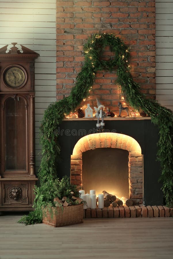 Fireplace with candles and pine needles. In a room lit festively decorated fireplace with candles and pine needles stock photo Fireplace with candles and pine needles. In a room lit festively decorated fireplace with candles and pine needles stock photo