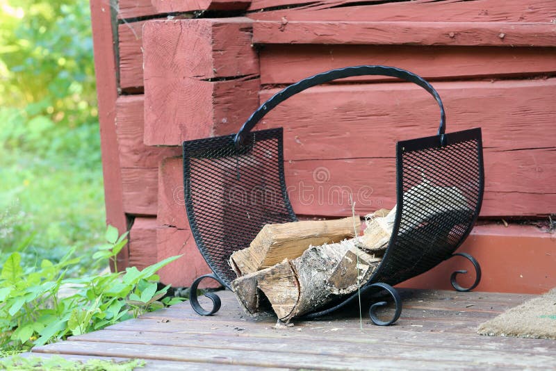 Black Metal Firewood Holder Loaded with Firewood for Sauna in Finland