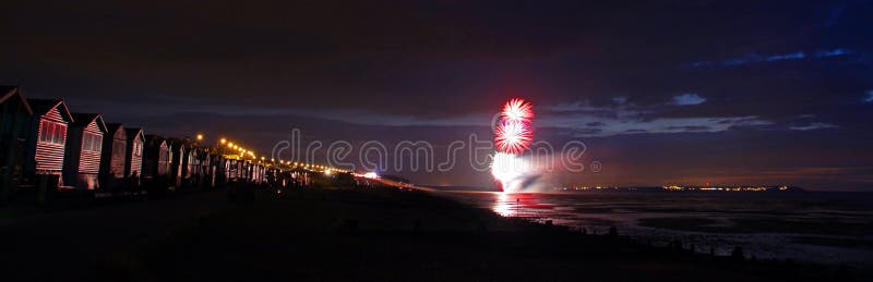 Foto di fuochi d'artificio sulla costa di whitstable, nel kent, con fuochi d'artificio illuminano le cabine alla spiaggia, sul lungomare.