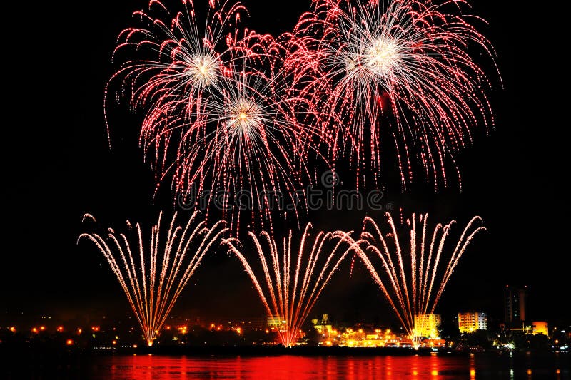 Firework over city at night with reflection in water