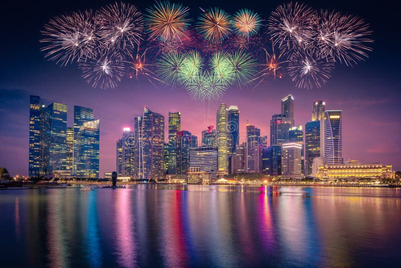 Firework over Singapore Skyline and view of skyscrapers on Marina Bay at twilight time.