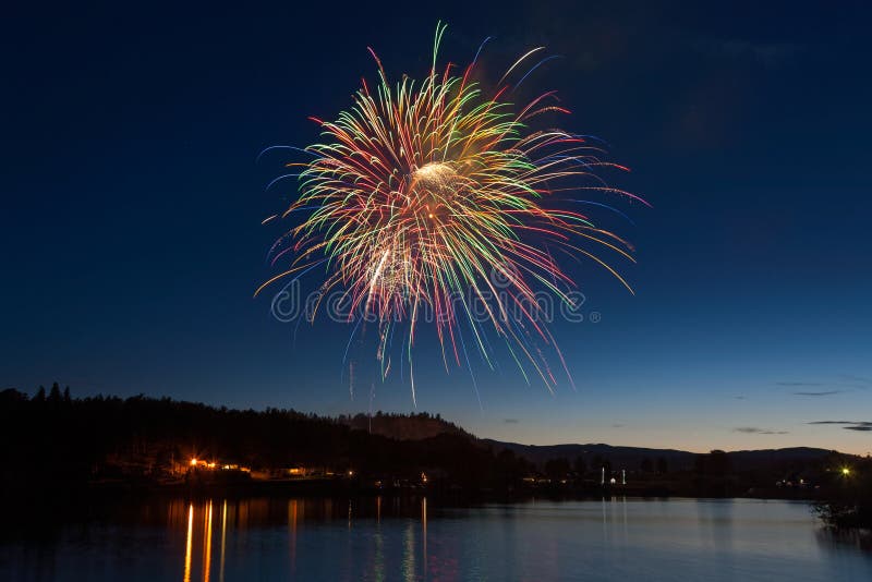 Celebration Fireworks Display Over a Mountain Lake at Dusk royalty free stock photos