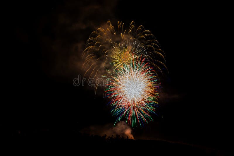 Fireworks Exploding Over the Mountains at night in Colorado stock photo