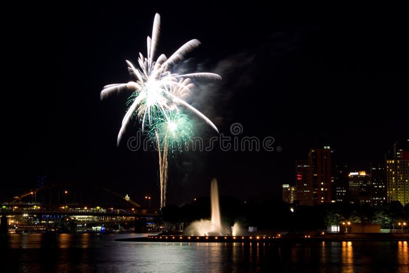 A firework display over the city of Pittsburgh, PA near the water fountain. A firework display over the city of Pittsburgh, PA near the water fountain.