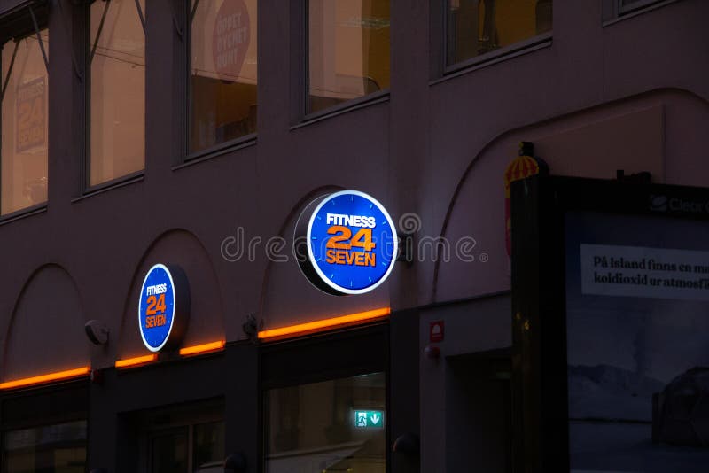 Malmö, Sweden - May 20 2019: A lit company sign for the gym Fitness 24/7 at Skomakargatan, Malmö, Sweden. Malmö, Sweden - May 20 2019: A lit company sign for the gym Fitness 24/7 at Skomakargatan, Malmö, Sweden