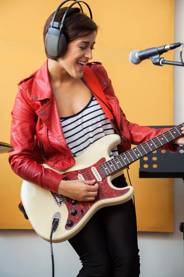 Firmante feliz que toca la guitarra en el estudio de grabación imágenes de archivo libres de regalías Firmante feliz que toca la guitarra en el estudio de grabación imágenes de archivo libres de regalías