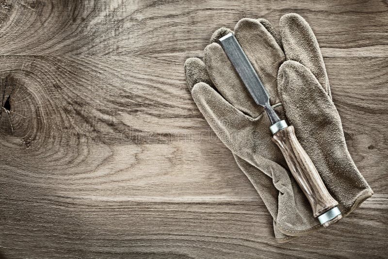 Firmer chisel working gloves on wooden board. Pair working gloves stock images, royalty-free photos and pictures