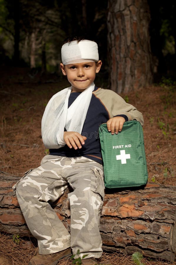 Prvá Pomoc treatmant vzhľadom na mladý chlapec v lese, ukazuje rameno závesu a poranenie hlavy.