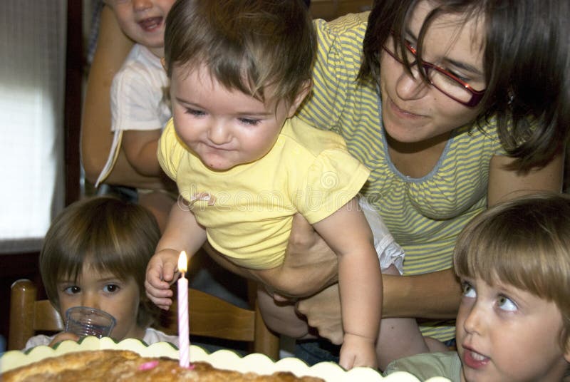 Madre a un nino celebra el primero, listo sobre el rapé afuera vela sobre el pastel.