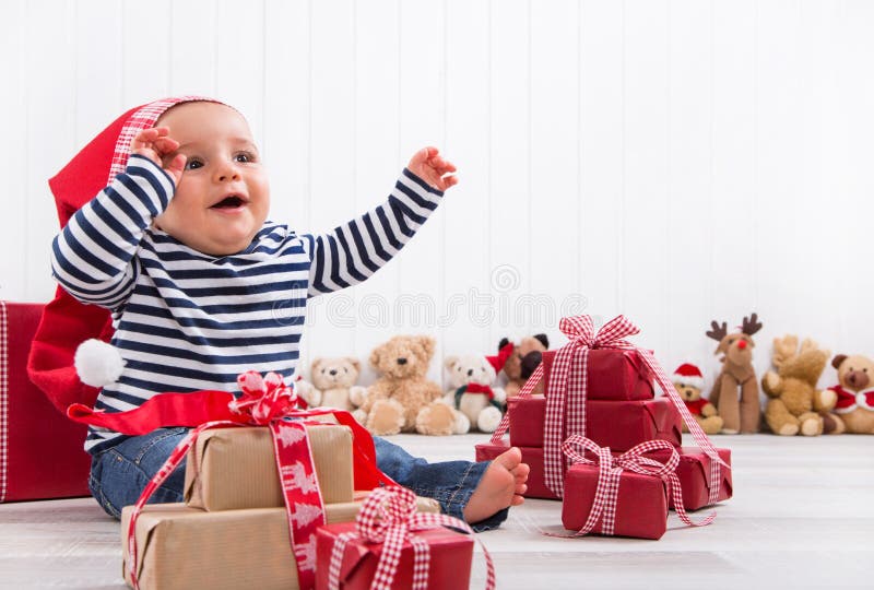 First Christmas: baby unwrapping a present royalty free stock photography