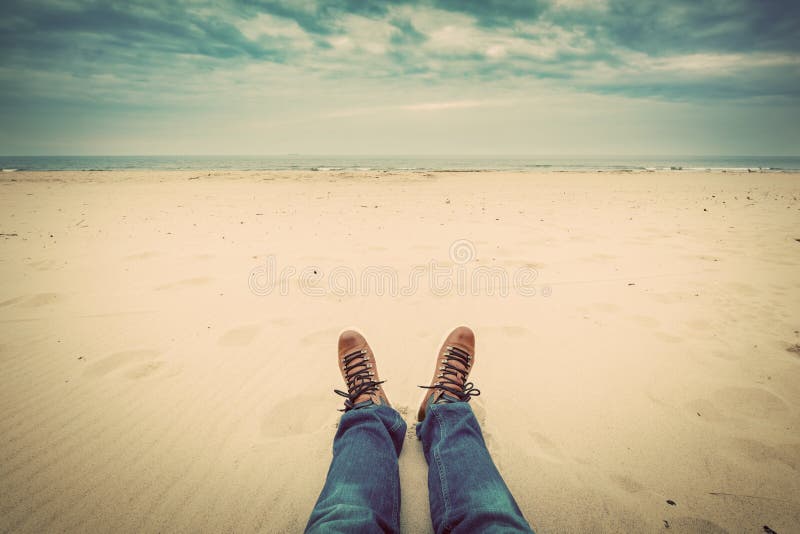 First person perspective of man legs in jeans on the autumn beach