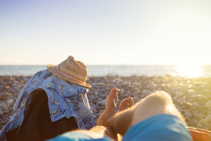 First person perspective of man legs on sunset beach. stock image